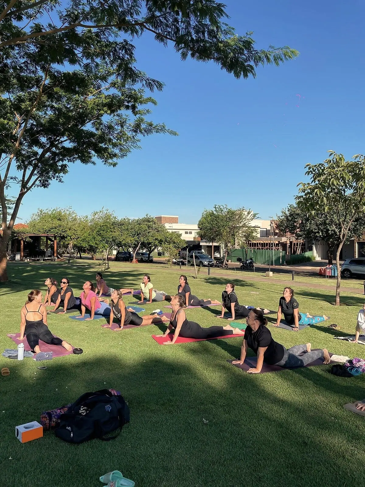 Alunos deitados em seus tapetes durante uma aula ao ar livre