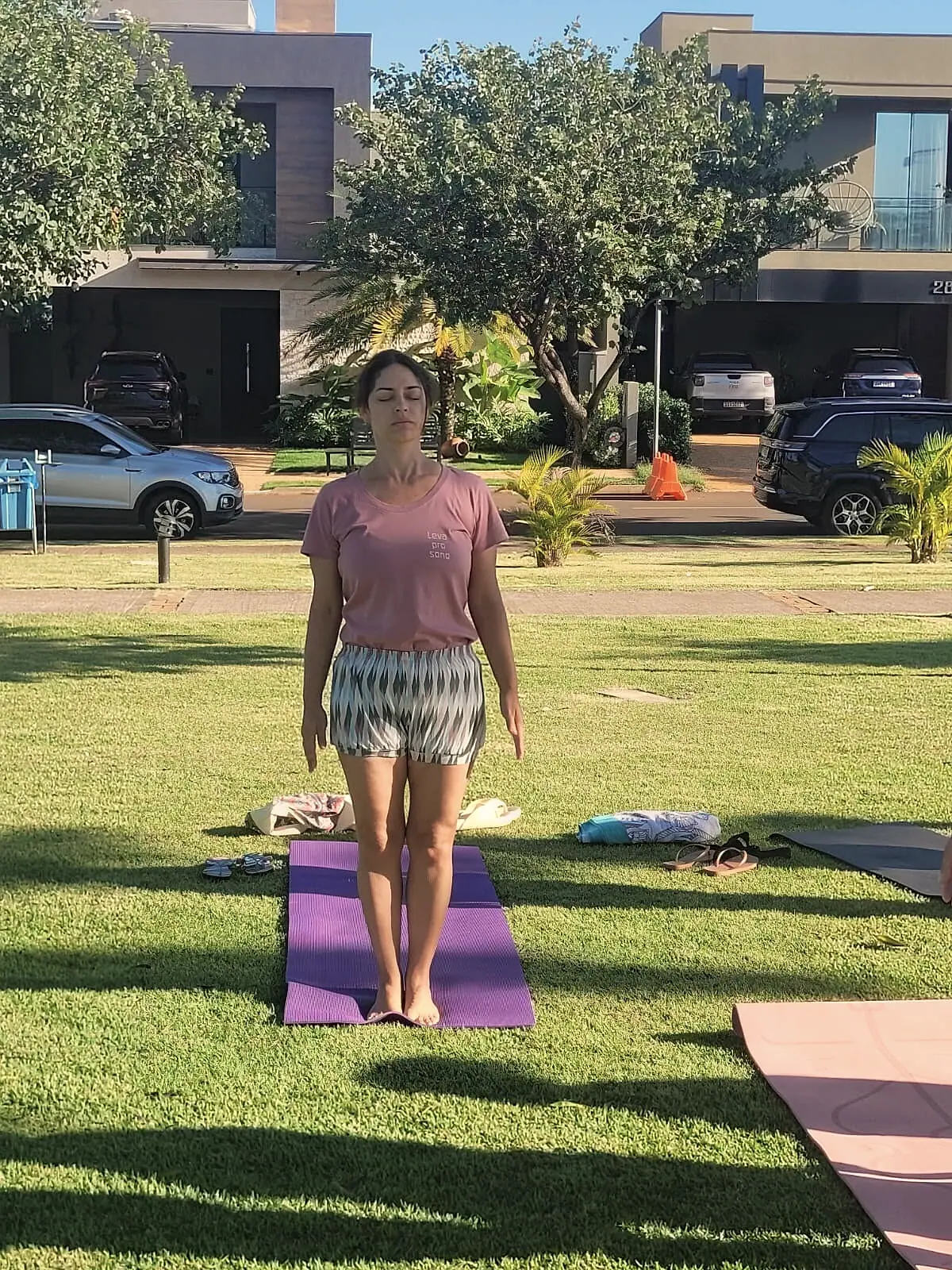Luciane Lemos em Tadasana conduzindo a aula no gramado
