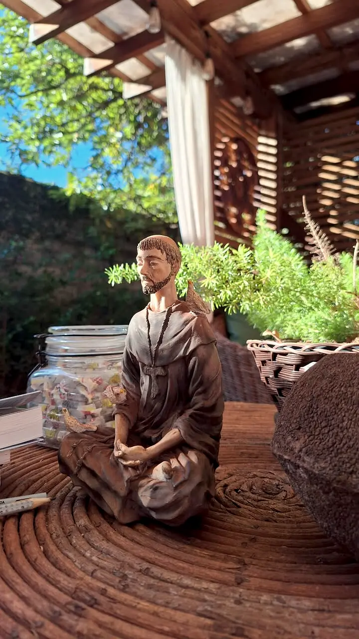 Estátua de um monge meditando entre plantas