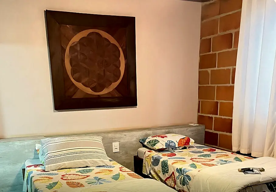 Suíte com duas camas de solteiro e quadro de Flor da Vida
